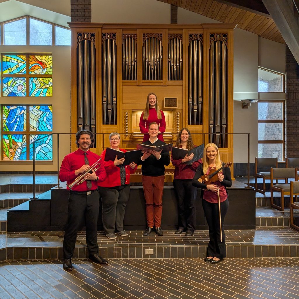 Holland Organist, Audrey Gorman, poses with the vocalists, violin, and trumpet soloists in front of our Dutch pipe organ to promote our organ recital.